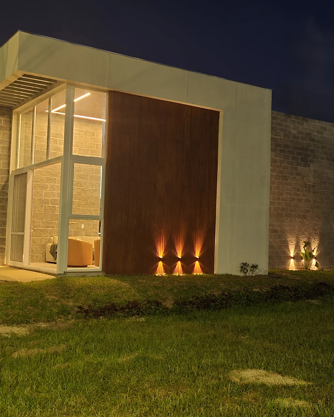Detalhe noturno da fachada com iluminação cênica