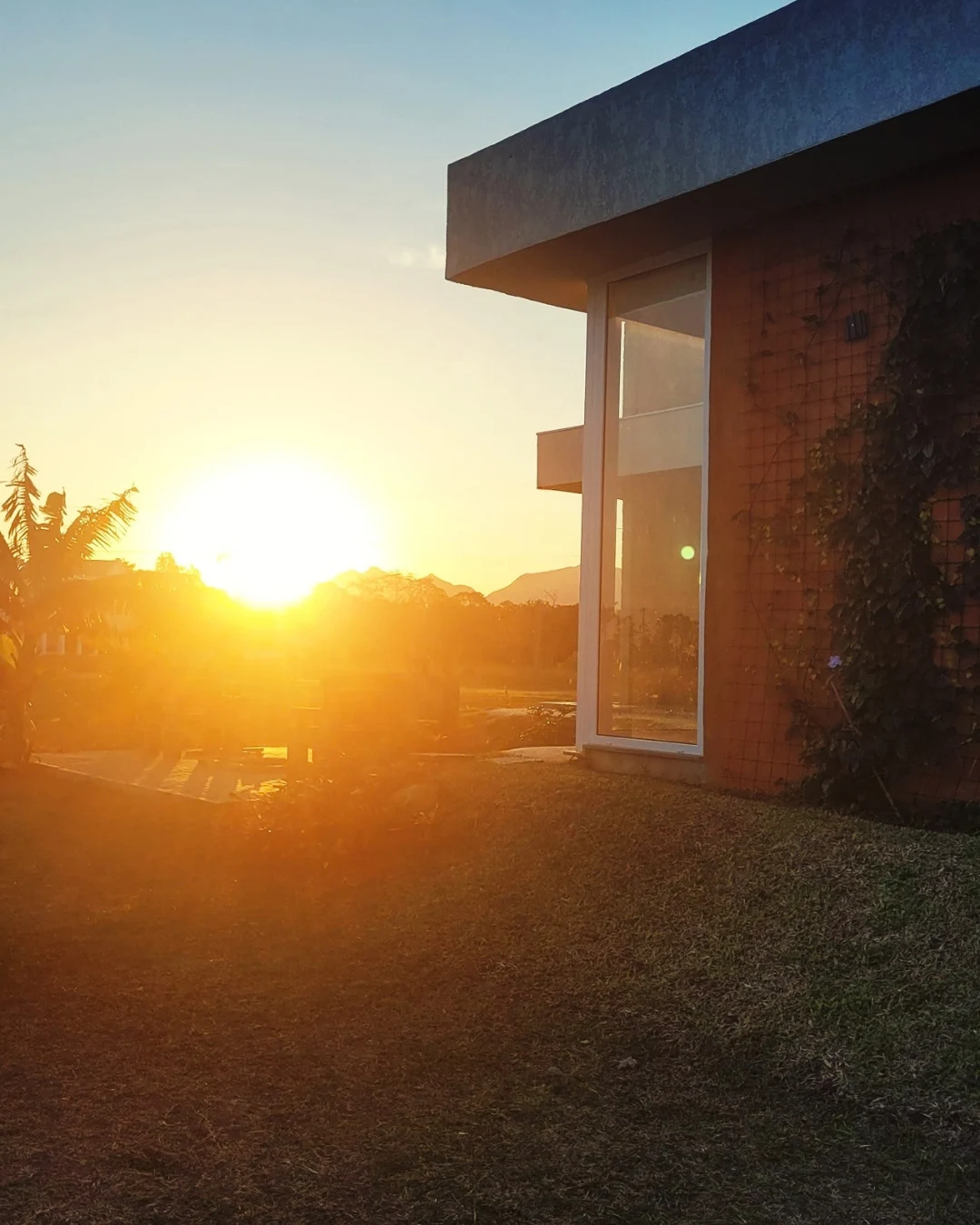 Vista lateral da arquitetura da Casa Carbono Zero ao pôr do sol
