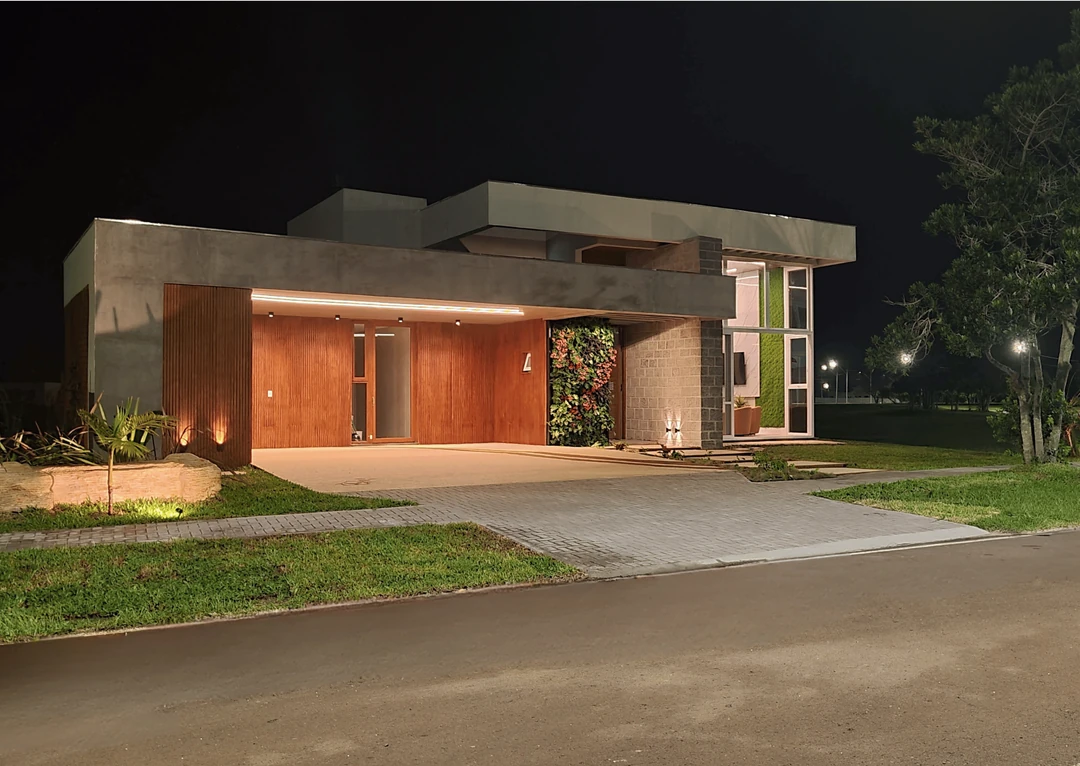 Fachada principal da Casa Carbono Zero com iluminação noturna